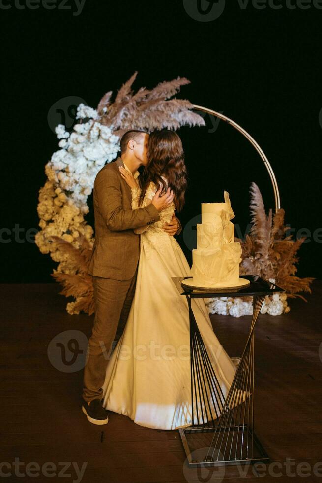 newlyweds happily cut and taste the wedding cake photo