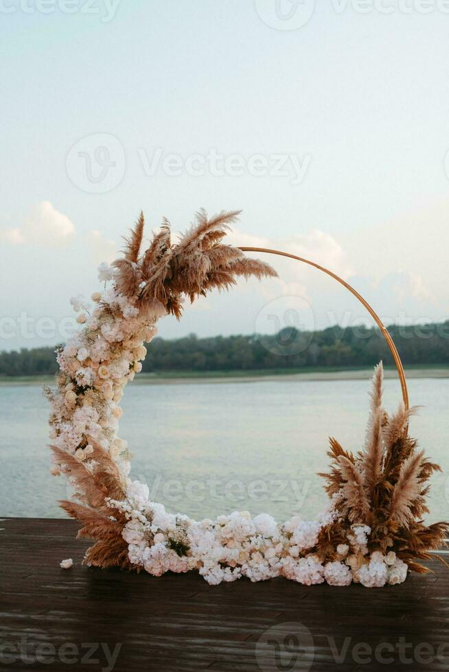 wedding round arch against the background of a river photo