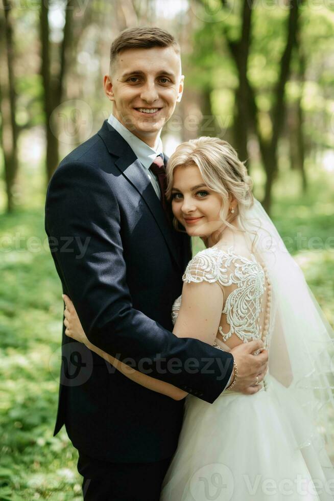 the groom and the bride are walking in the forest photo