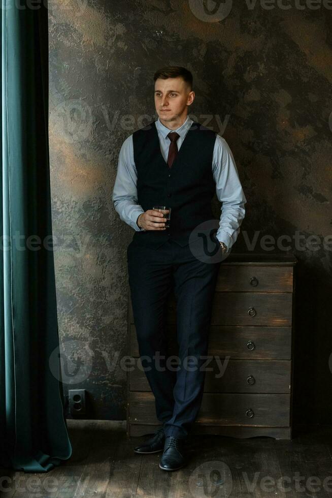 portrait of a cheerful groom in a blue suit photo