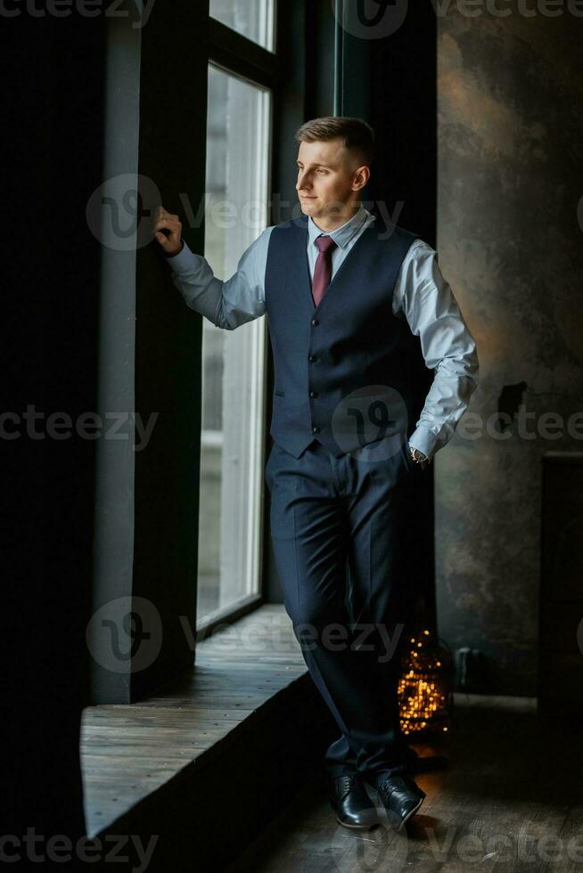 portrait of a cheerful groom in a blue suit photo