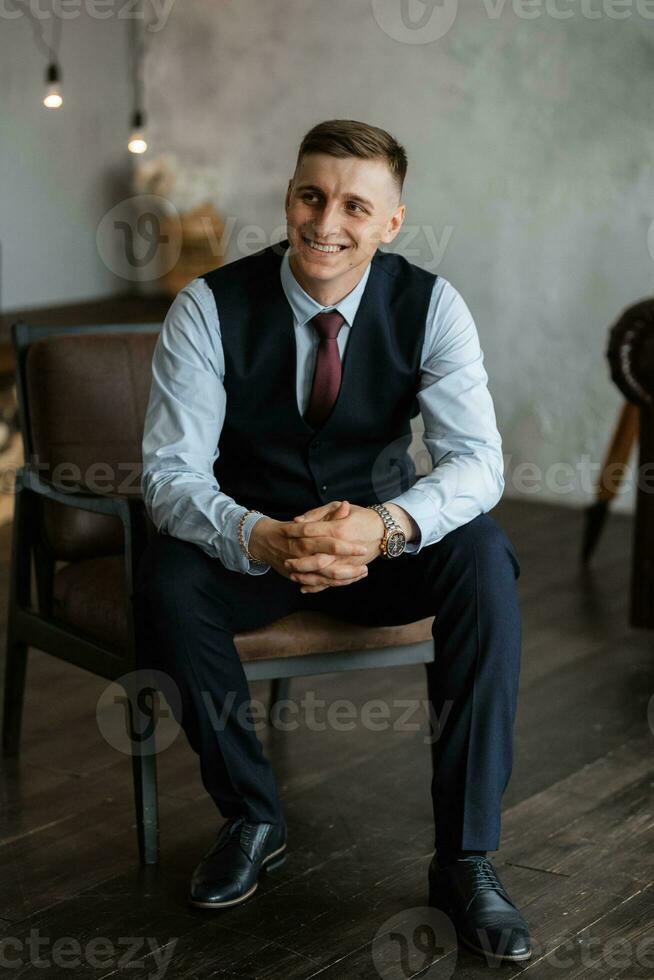 portrait of a cheerful groom in a blue suit photo