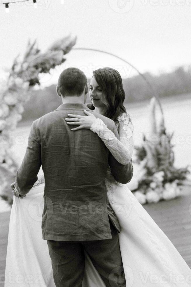 el primero Boda danza de el novia y novio en el muelle cerca el río foto