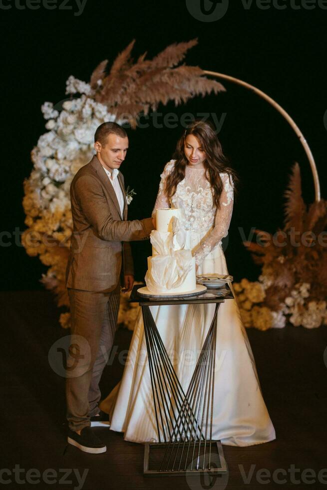 newlyweds happily cut and taste the wedding cake photo