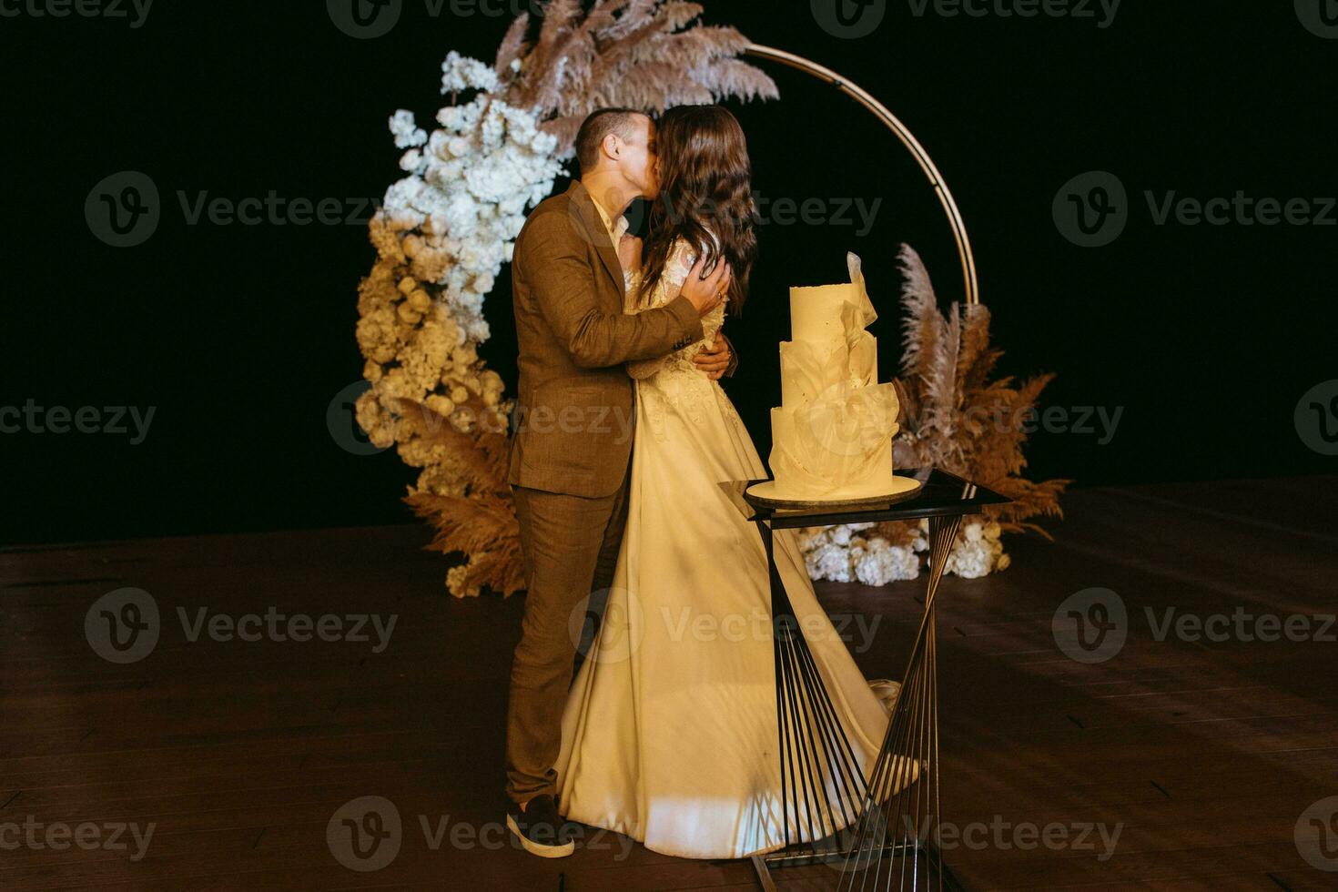 los recién casados felizmente cortan y prueban el pastel de bodas foto