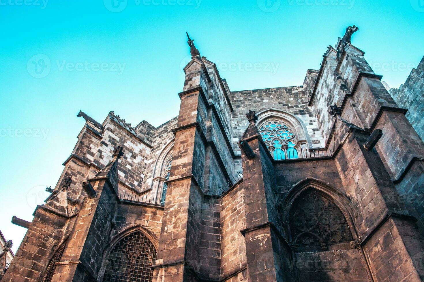 Photo of cathedral in the old Gothic Quarter, Barcelona, Catalonia. Side view of medieval wall in Catalonia