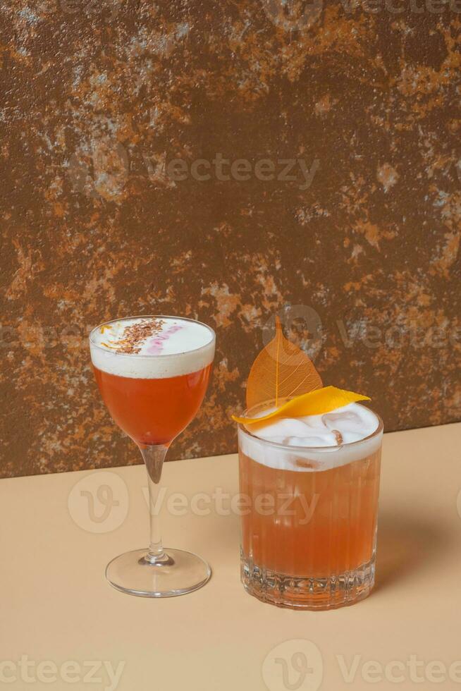 Bright alcoholic cocktails in glasses on beige brown background. photo