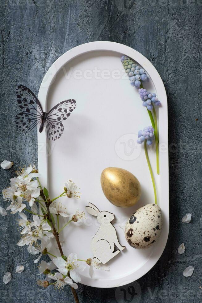 Easter composition with flowers, white rabbit and eggs flat lay, top view. Copy space. photo