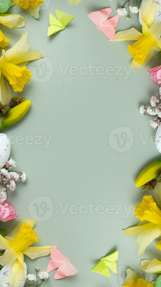 Spring flowers ans easter eggs border on green background with copy space. Easter greeting card template photo