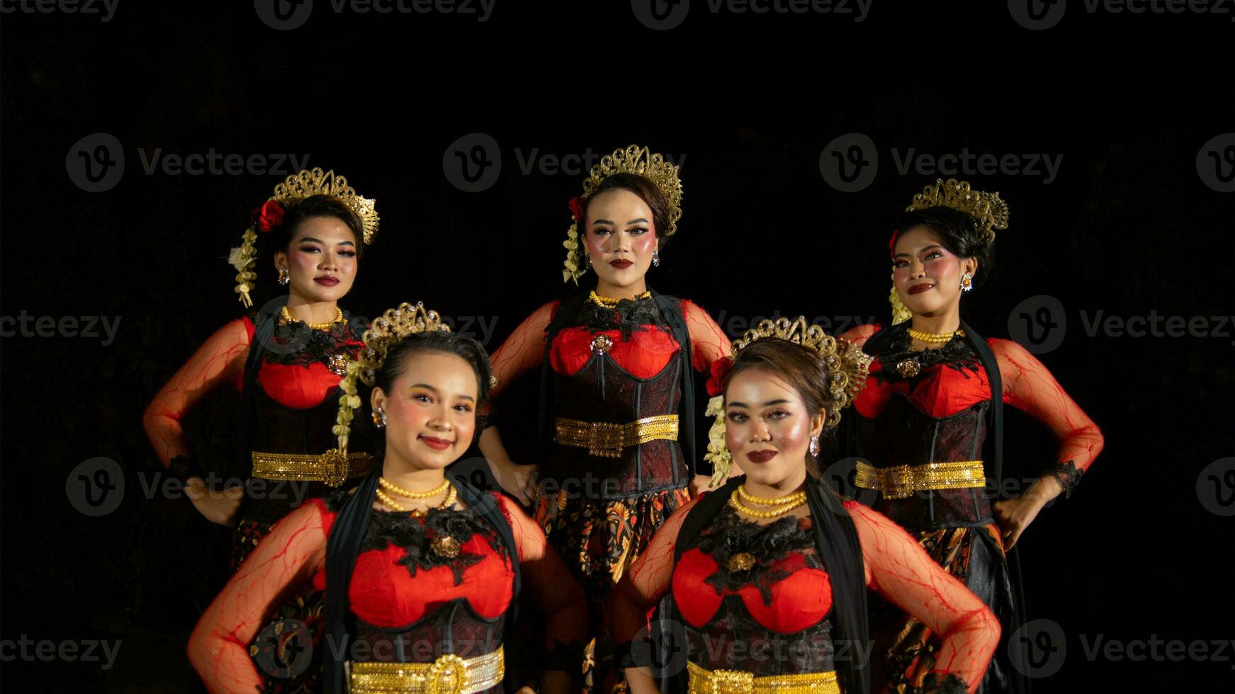 un grupo de bailarines estar alto como rojo disfraces proporcionar un dramático y agraciado contraste foto