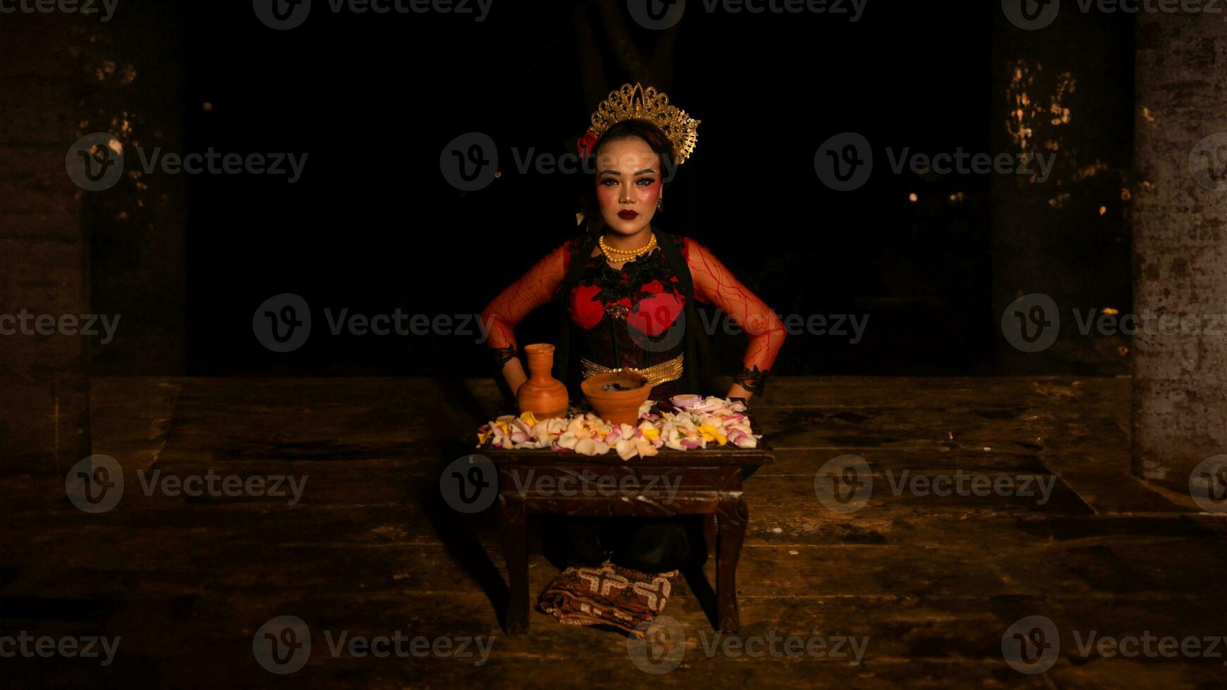 a female dancer sits gracefully and begins her ritual in front of beautiful offerings photo