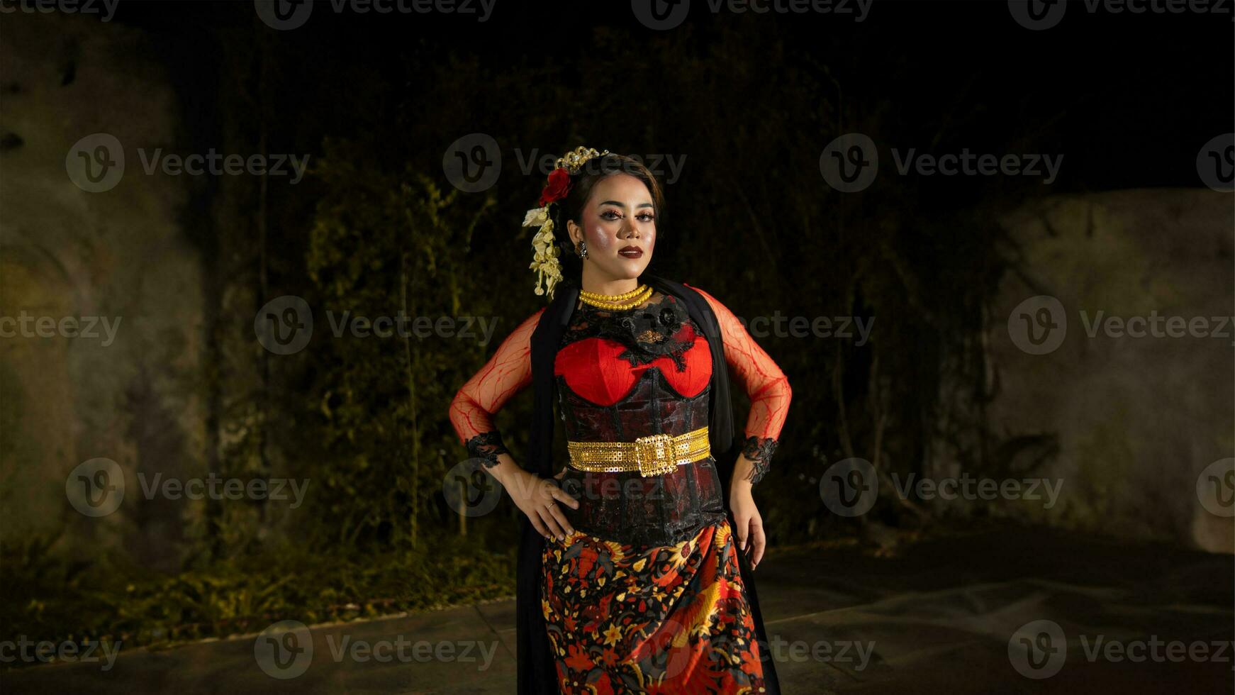 a female dancer in a red dress danced on stage, reflecting the beauty of her movements and adding to the charm of her performance photo
