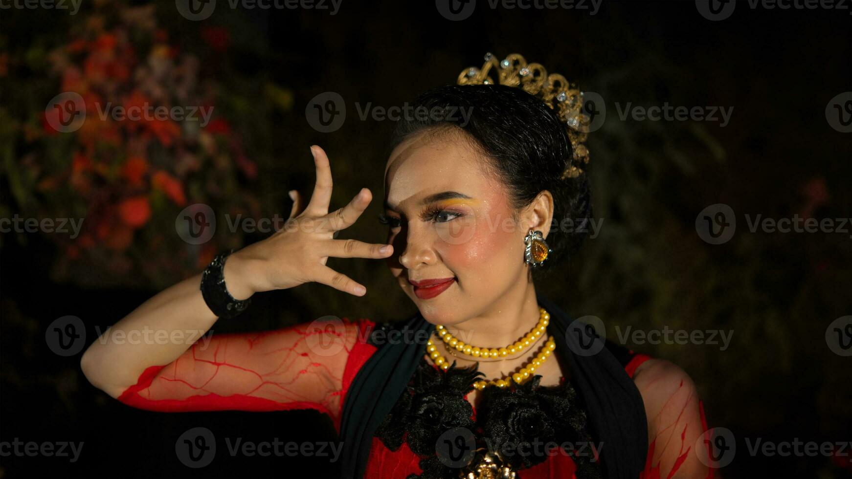 an Indonesian dancer radiates charm that attracts the attention of the audience throughout the performance with her red dress photo