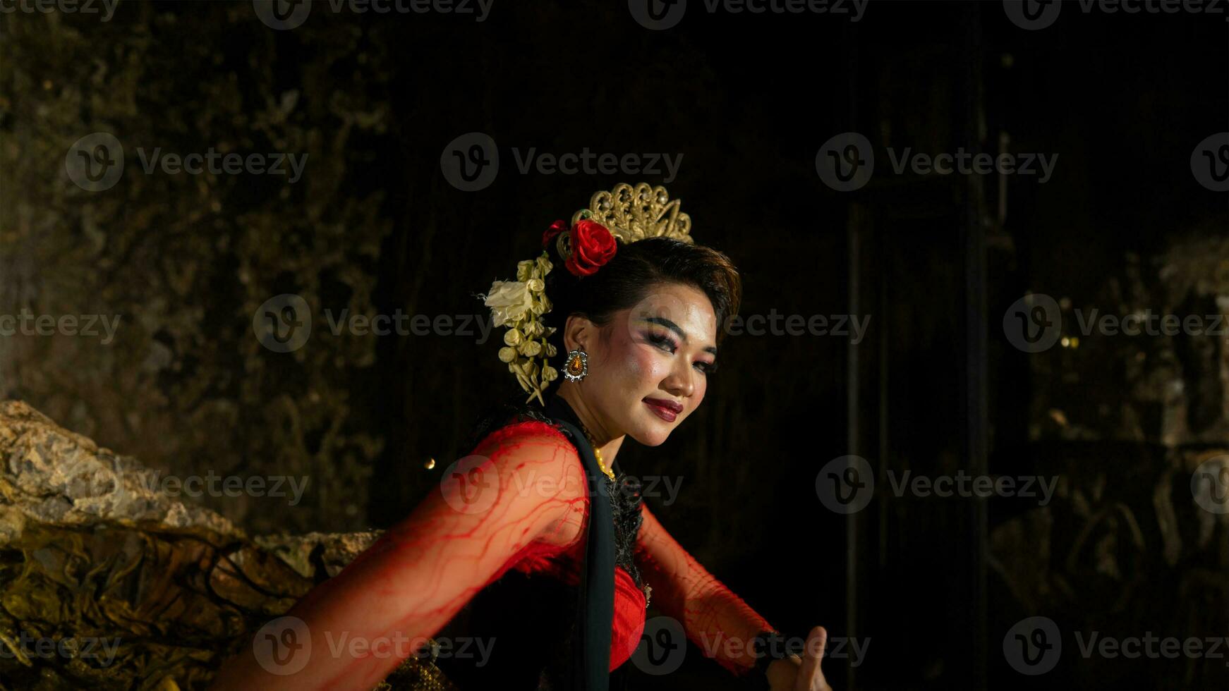 an Asian dancer dancing in front of the yard in a red costume photo