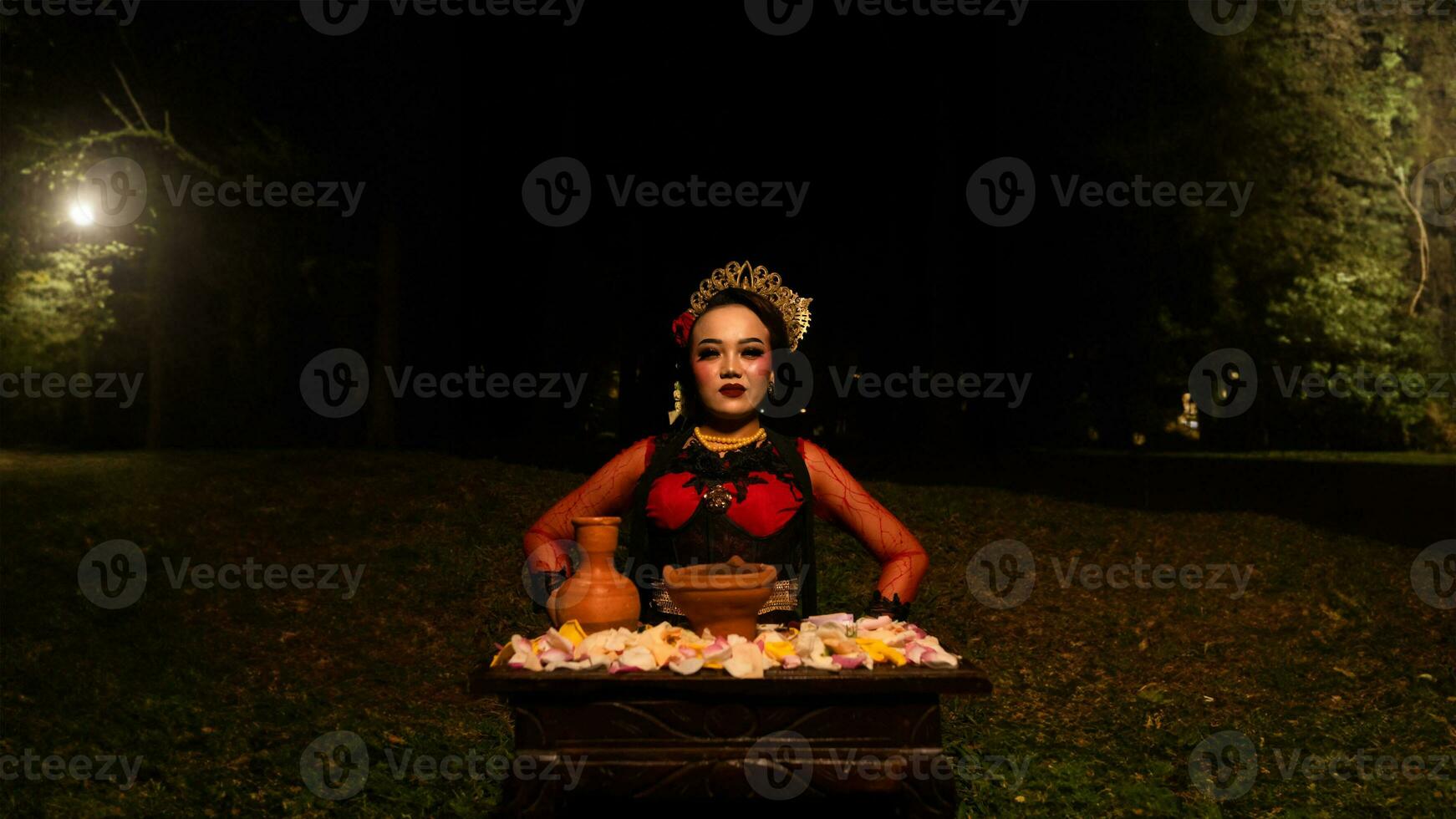 un hembra bailarín realiza un ritual ese crea un mágico y místico atmósfera en frente de flor ofrendas foto