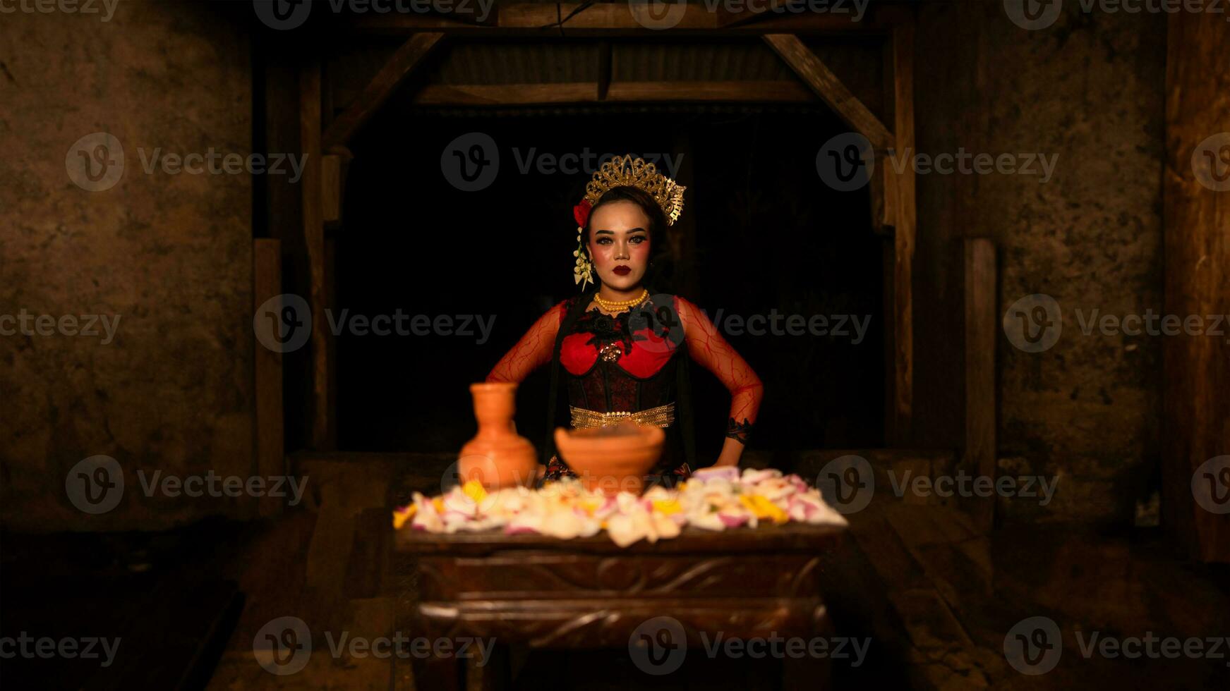 a female dancer sits gracefully and begins her ritual in front of beautiful offerings photo