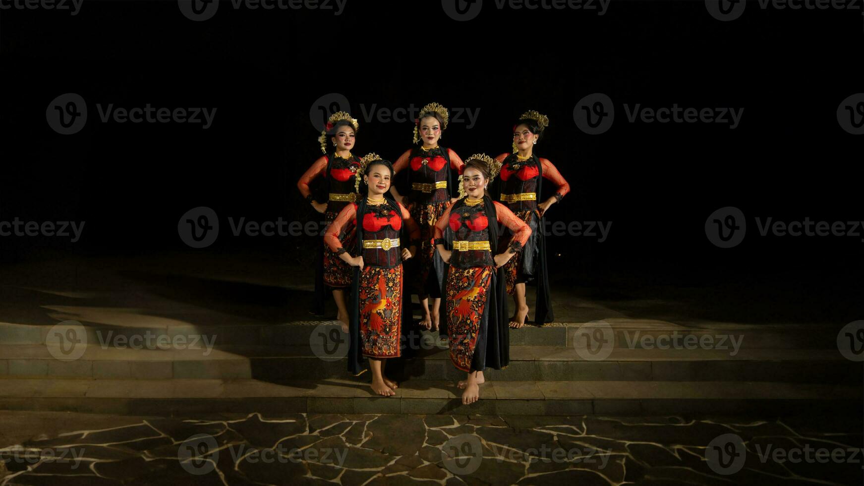 a group of dancers stand and unite in red costumes that show unity photo