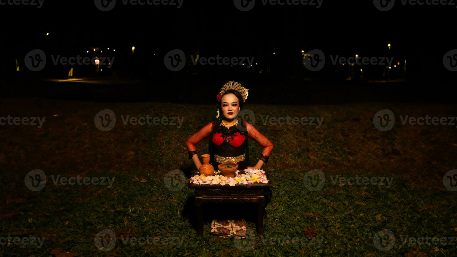 un hembra bailarín realiza un ritual ese crea un mágico y místico atmósfera en frente de flor ofrendas foto