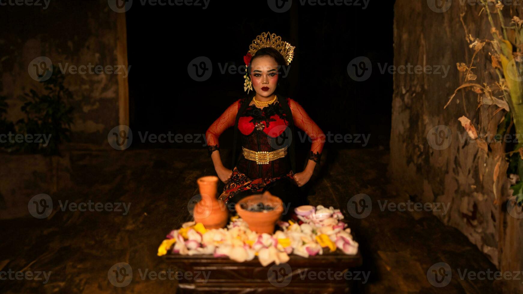 a female dancer sits gracefully and begins her ritual in front of beautiful offerings photo