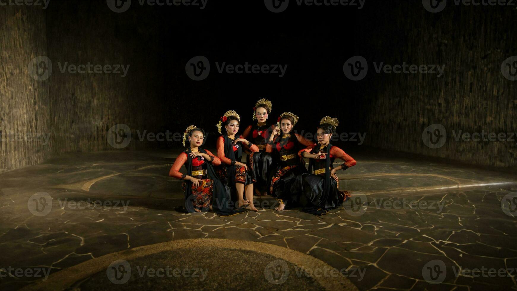 a group of dancers attract attention in striking red costumes and sit together photo