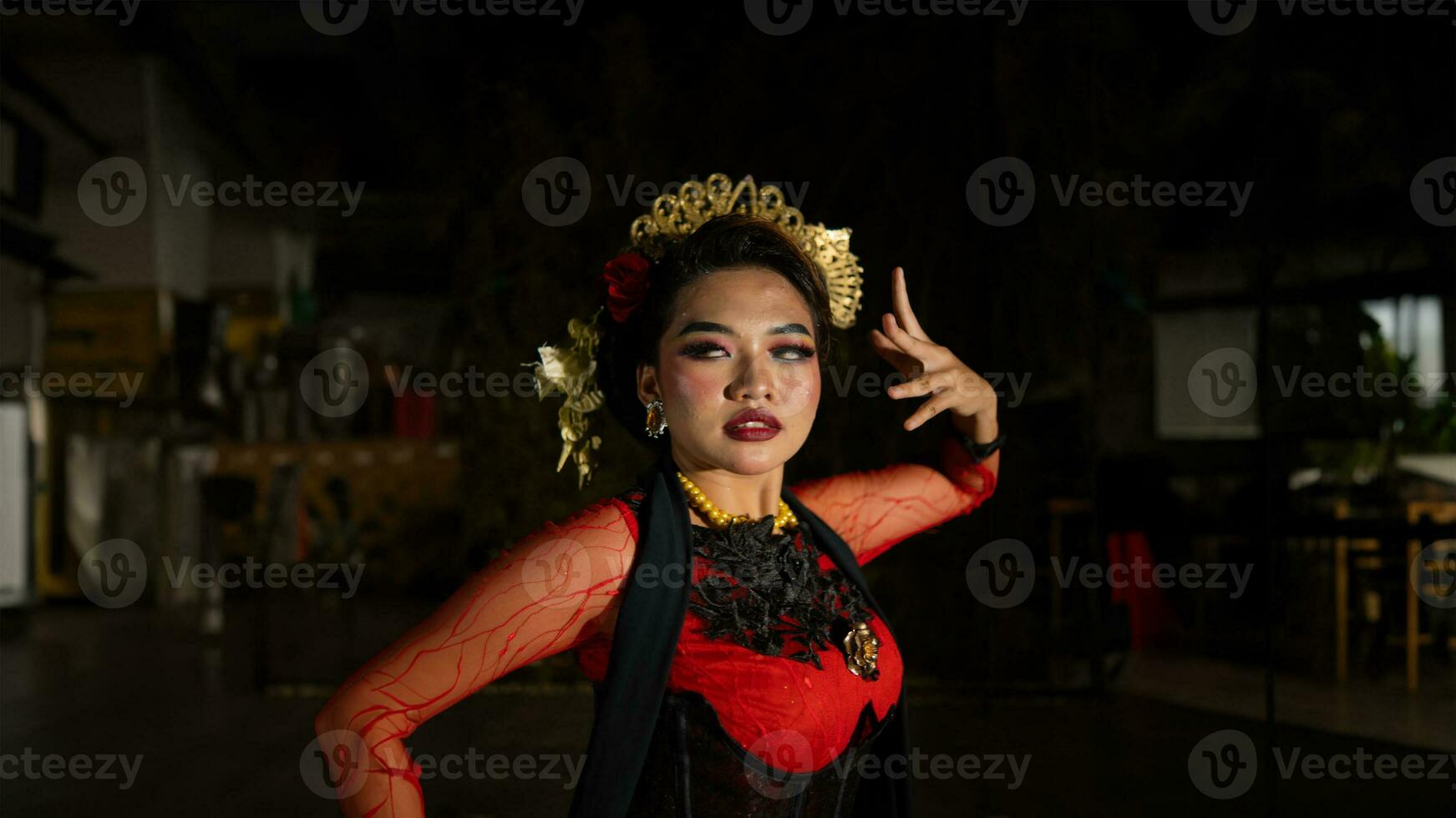 an Asian dancer dancing in front of the yard in a red costume photo