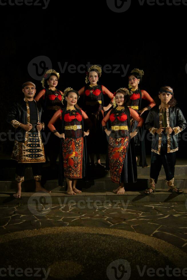 a group of dancers stand tall as red costumes provide a dramatic and graceful contrast photo