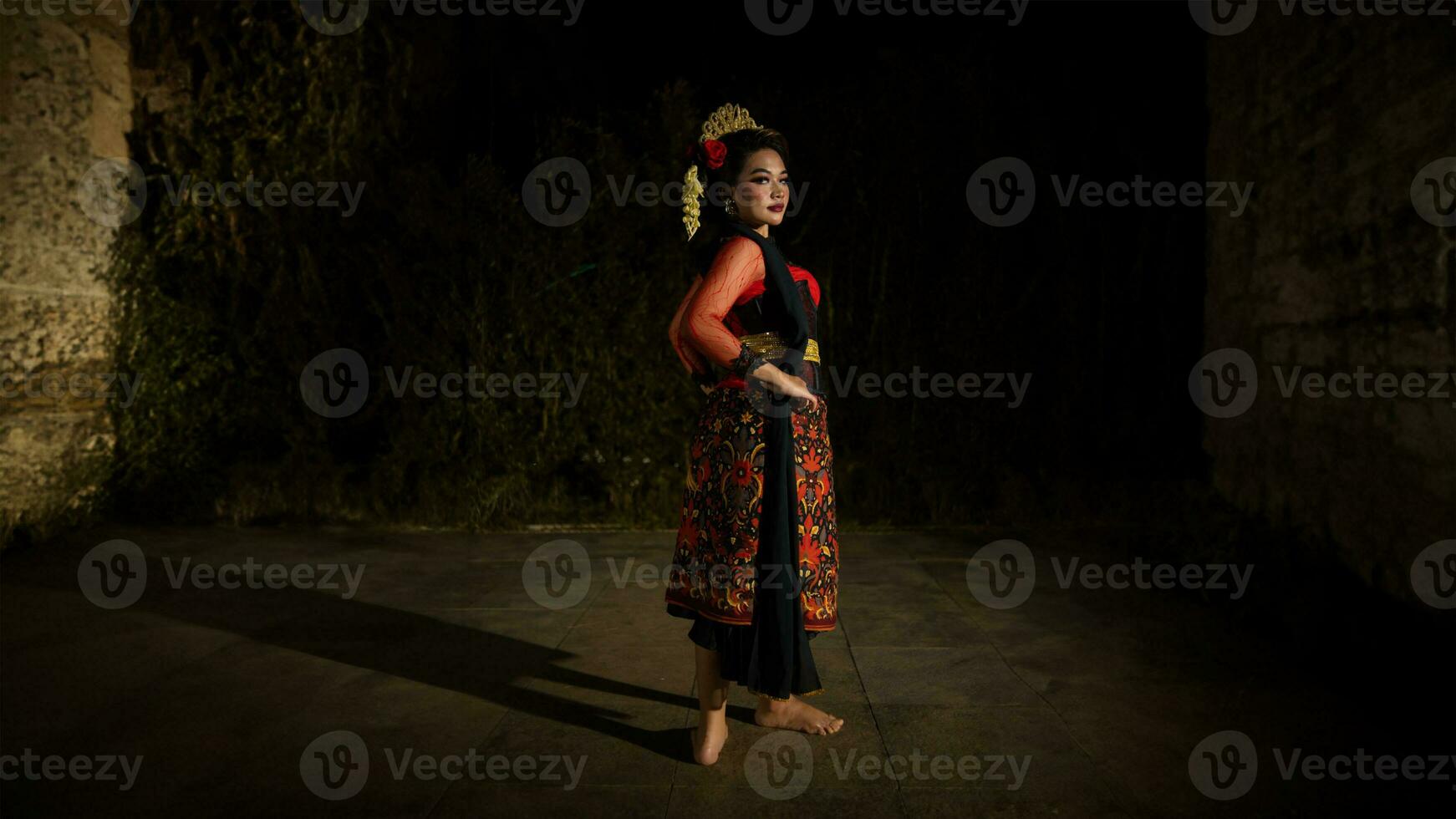 an Indonesian dancer wearing jewelry that shines under the spotlight of the stage lights adds to the brilliance of the performance photo