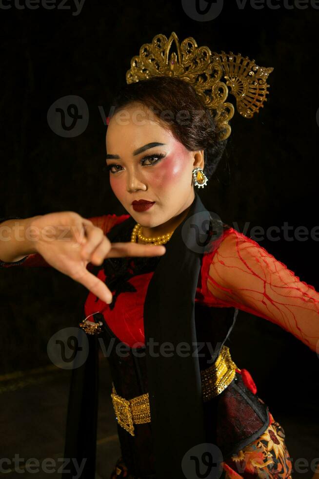 a Balinese woman wears heavy makeup with rosy red lips and sharp hair when posing photo