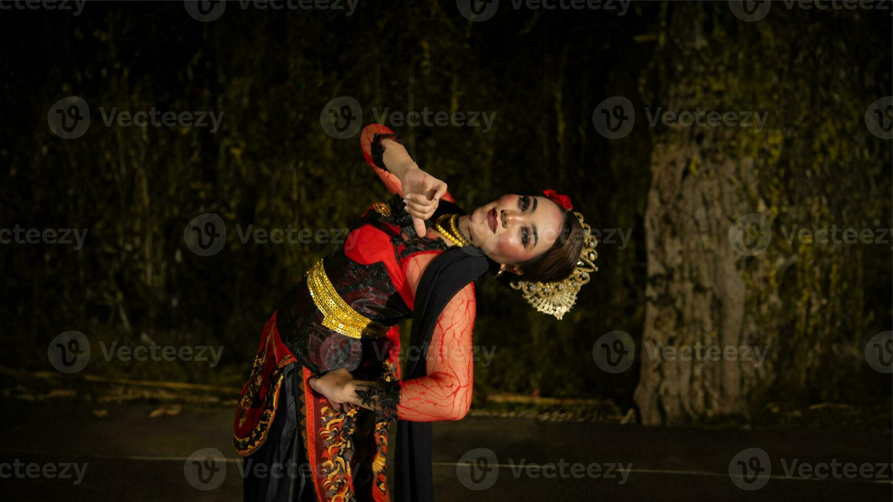 un javanés bailarín en un rojo disfraz presentado un danza ese cautivado el audiencia con su habilidad foto