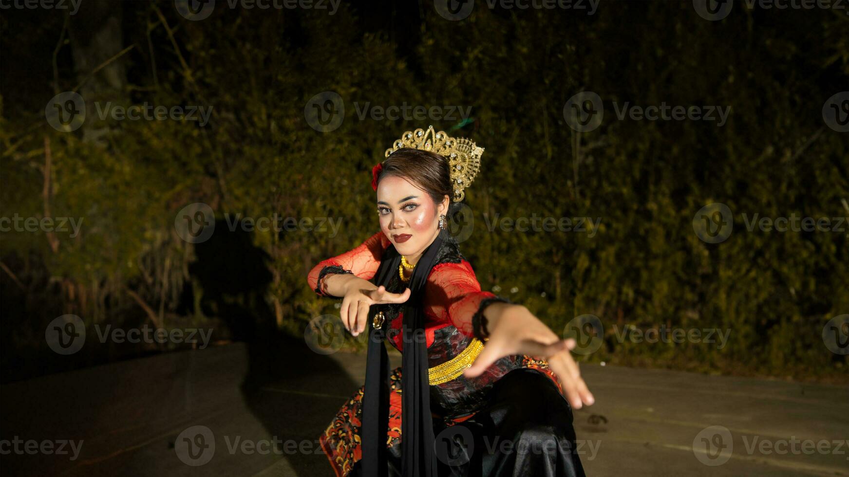 a female dancer in a red dress danced on stage, reflecting the beauty of her movements and adding to the charm of her performance photo