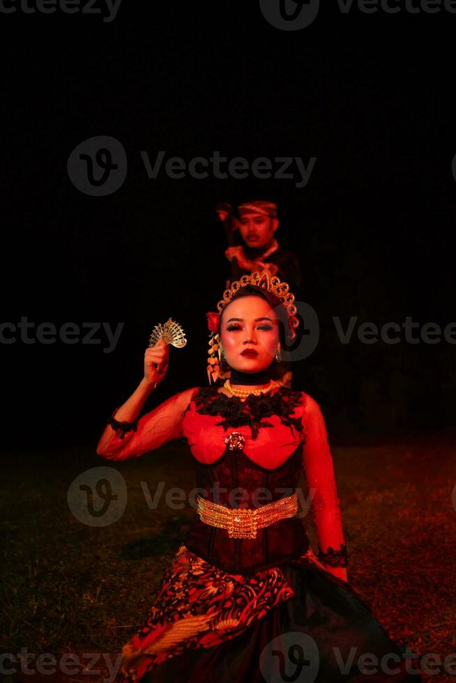 a female dancer in a red costume sat in the silence of the night which strengthened the sadness photo