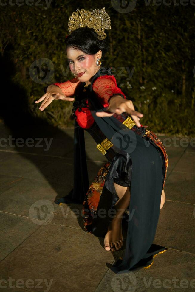 un javanés bailarín bailando con oro accesorios y un cara lleno de maquillaje foto