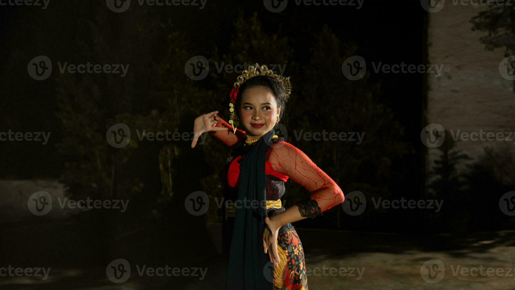 an Indonesian dancer radiates charm that attracts the attention of the audience throughout the performance with her red dress photo