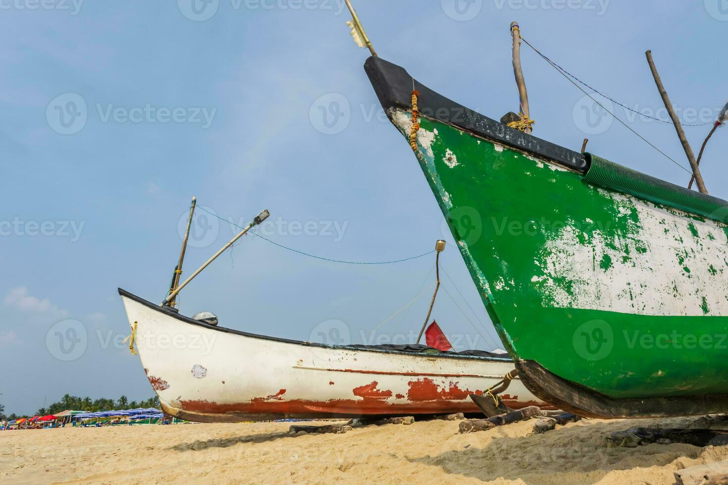 old fishing boats in sand on ocean in India on blue sky background photo