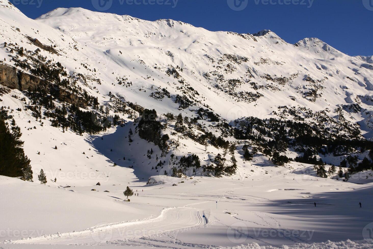 Fresco esquí Pendiente y montañas en soleado día foto