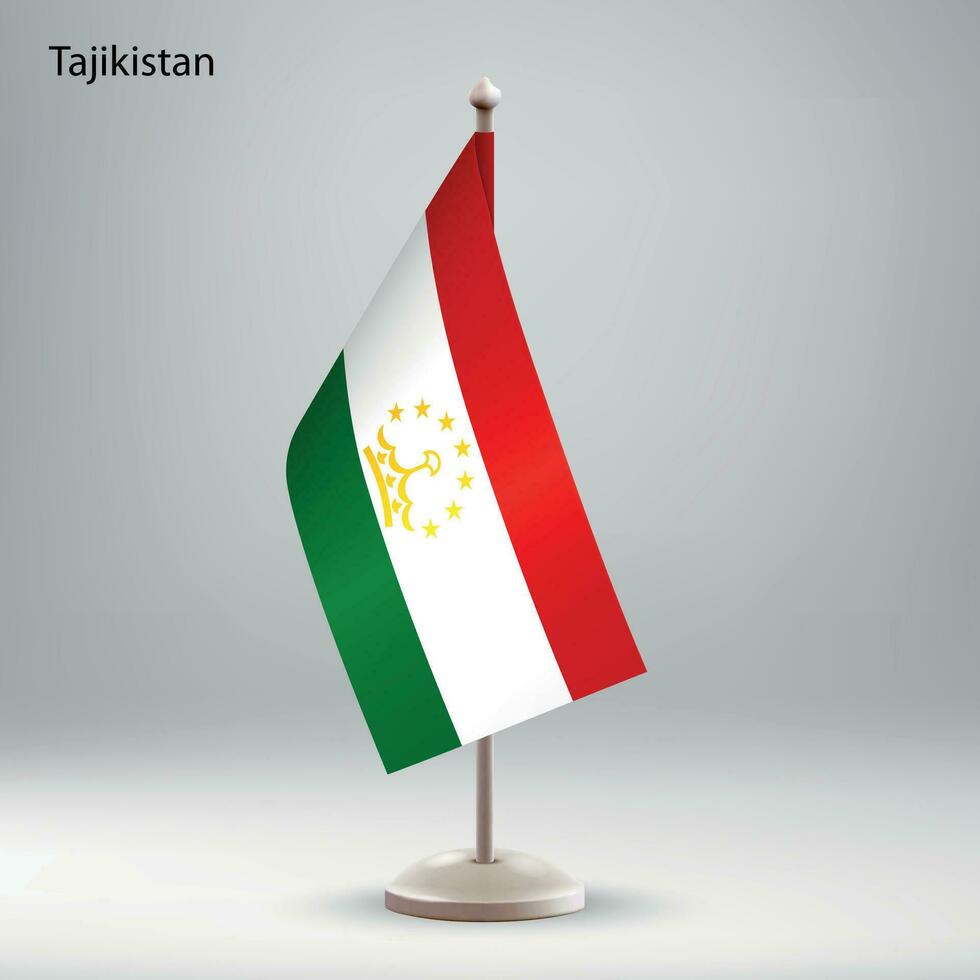 Flag of Tajikistan hanging on a flag stand. vector