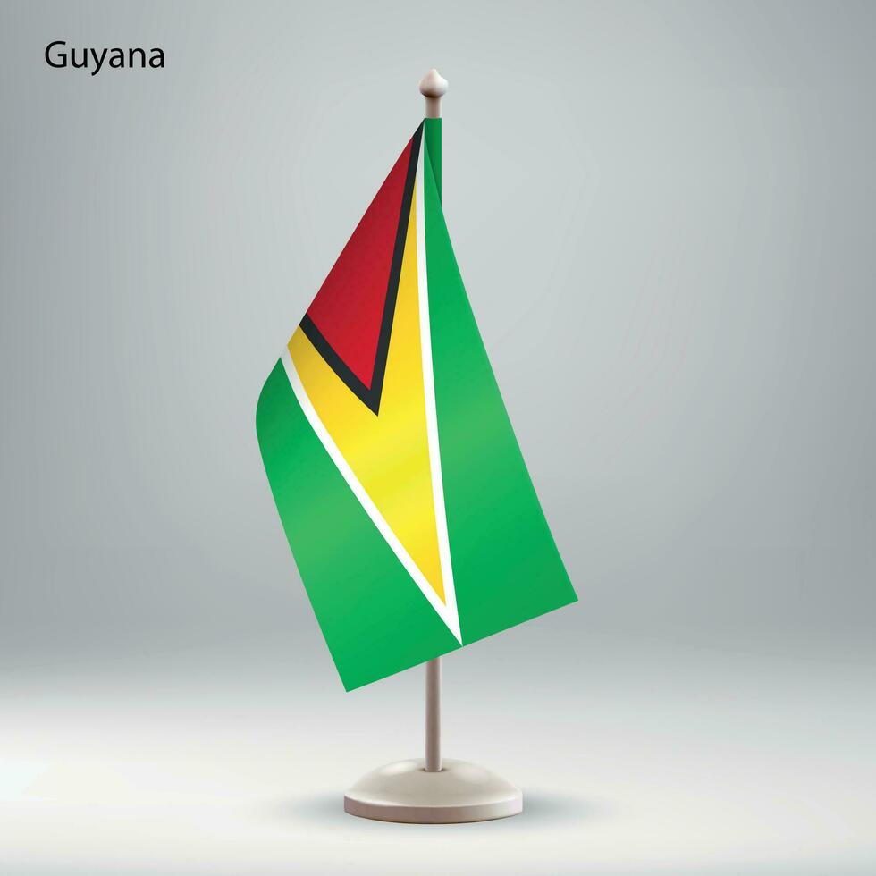 Flag of Guyana hanging on a flag stand. vector