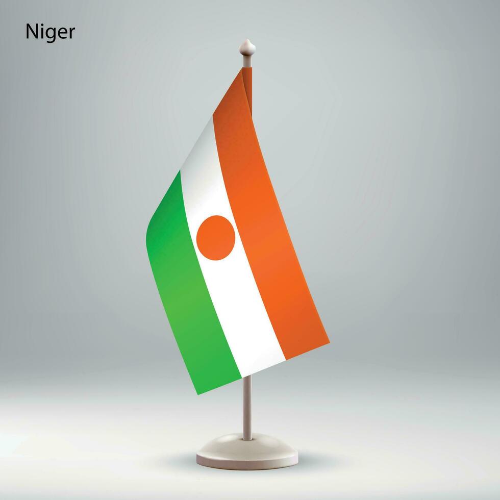 Flag of Niger hanging on a flag stand. vector