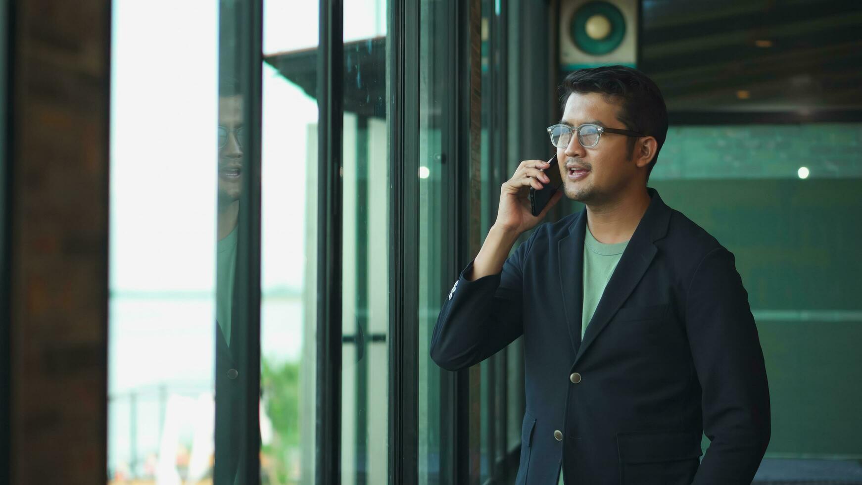 Asian business man  talking on the phone in the office,  Asian working  at the window . photo