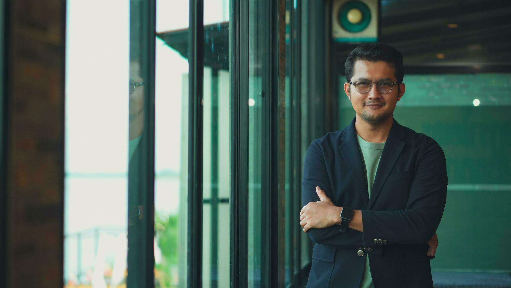 Handsome 38 years old gentle asian  man, wearing glasses, formal slick hairstyle,  in a modern office building beside a huge window photo