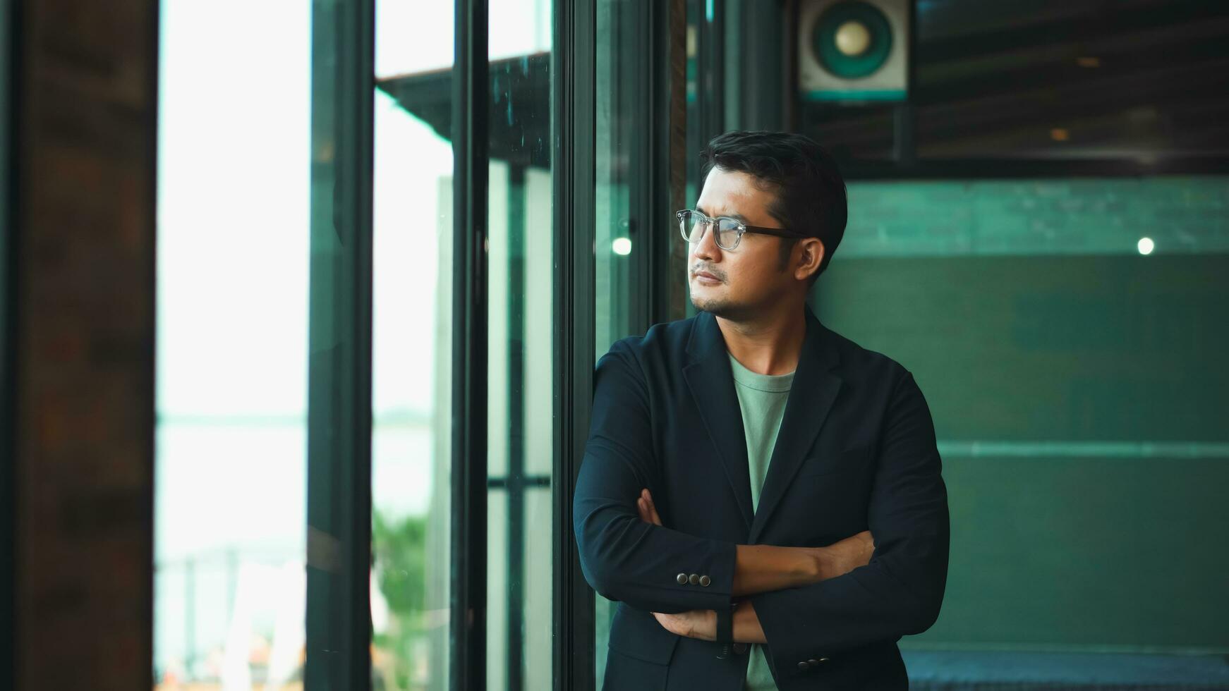 Handsome 38 years old gentle asian  man, wearing glasses, formal slick hairstyle,  in a modern office building beside a huge window photo