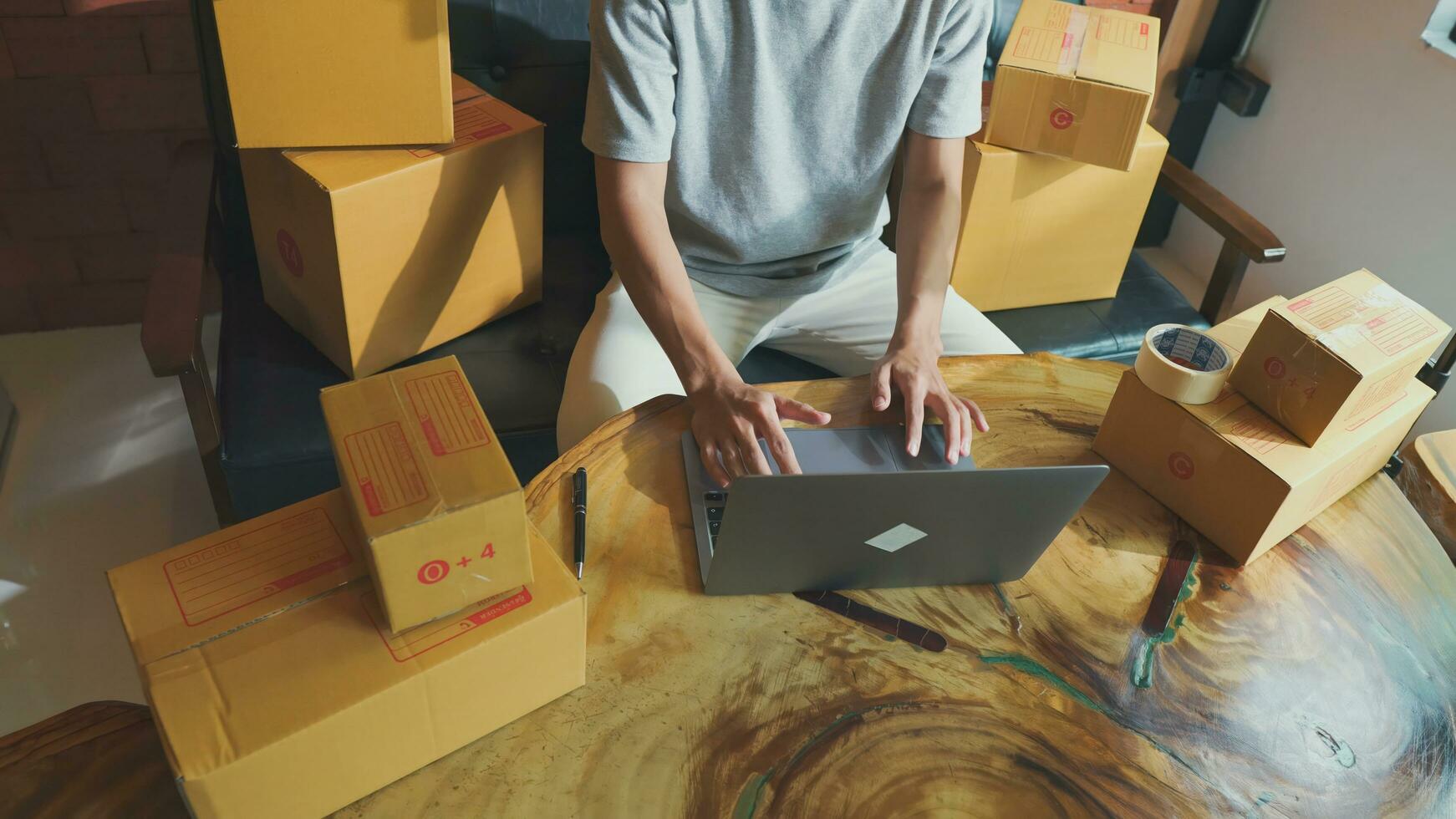 Asian man seller using laptop answer questions the delivery  for the customer, online sales, or ecommerce. photo