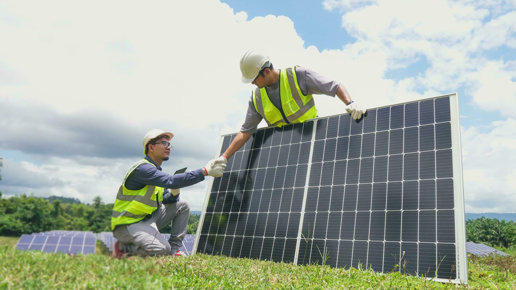 Two asian engineers shaking hands after  installing solar panels . Solar energy clean and green alternative energy. Unity and teamwork. photo