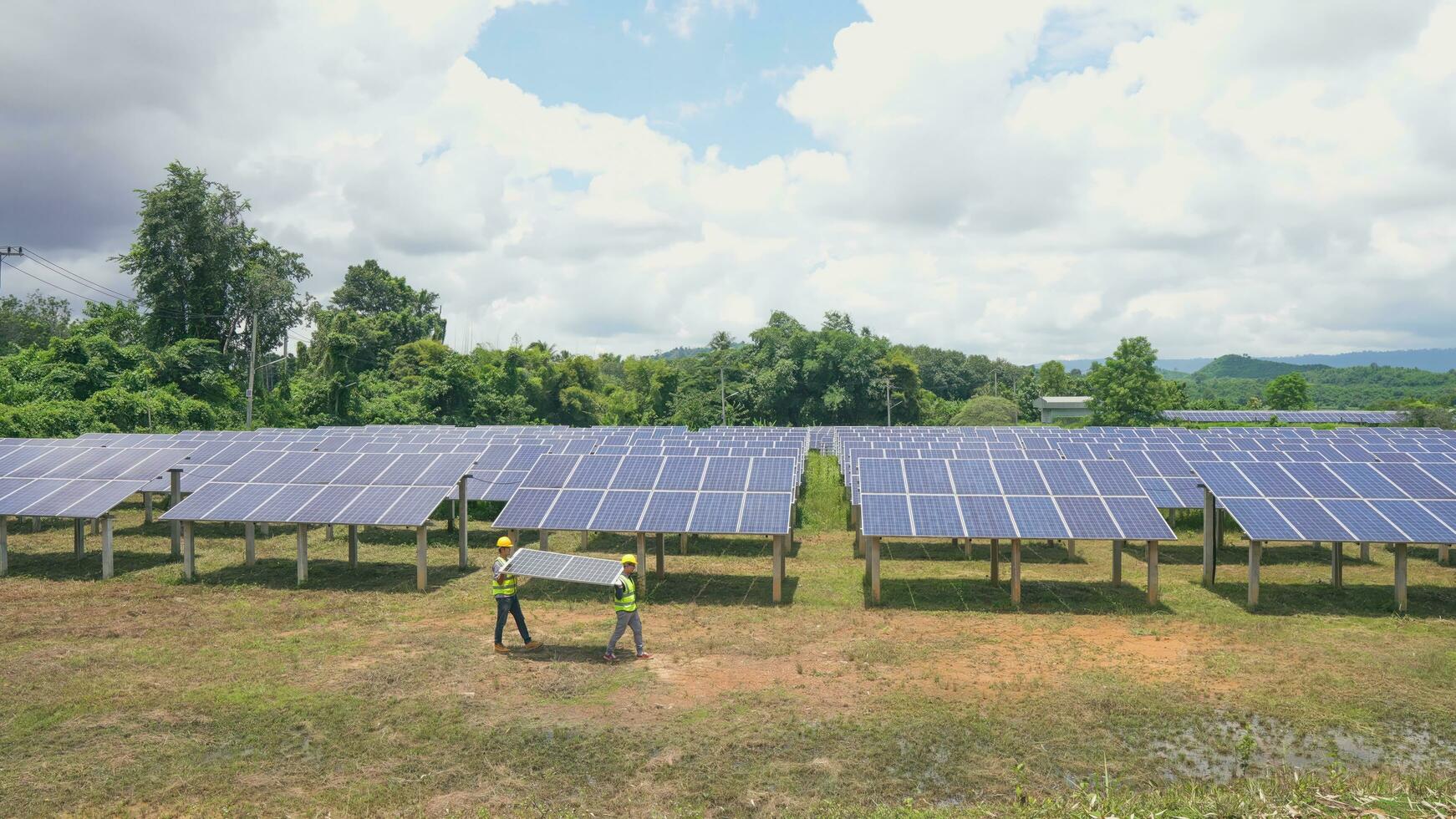 Two asian engineers installing solar panels . Solar energy clean and green alternative energy. Unity and teamwork. photo
