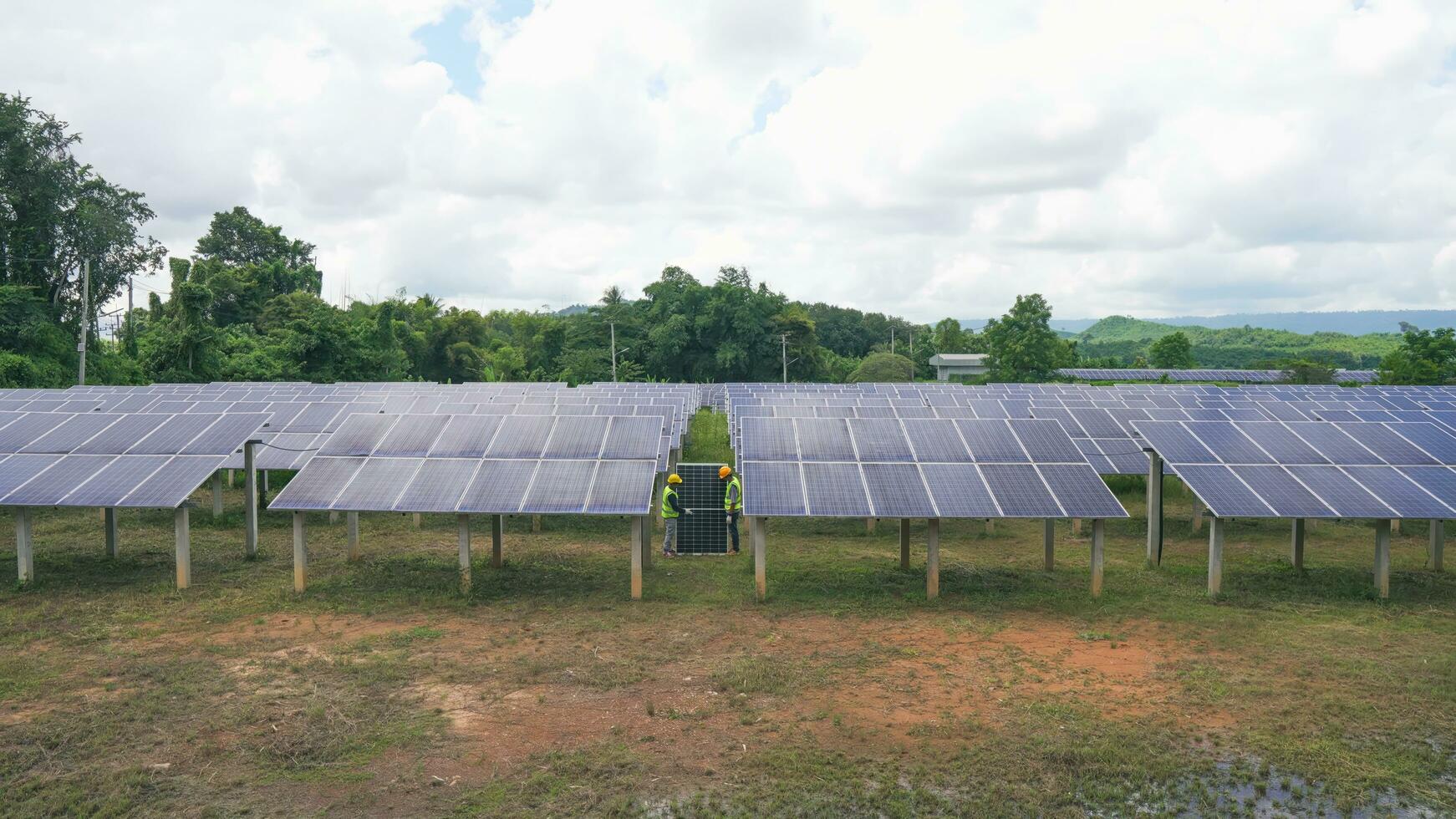 Two asian engineers installing solar panels . Solar energy clean and green alternative energy. Unity and teamwork. photo