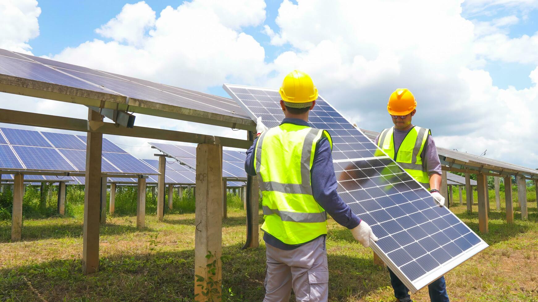 Two asian engineers installing solar panels . Solar energy clean and green alternative energy. Unity and teamwork. photo