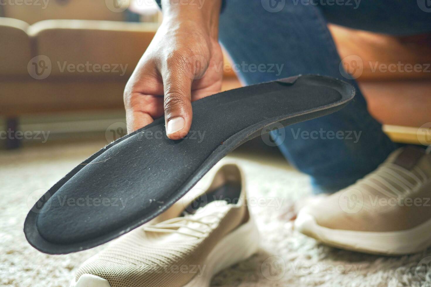 men hand putting Orthopedic insoles in shoes photo