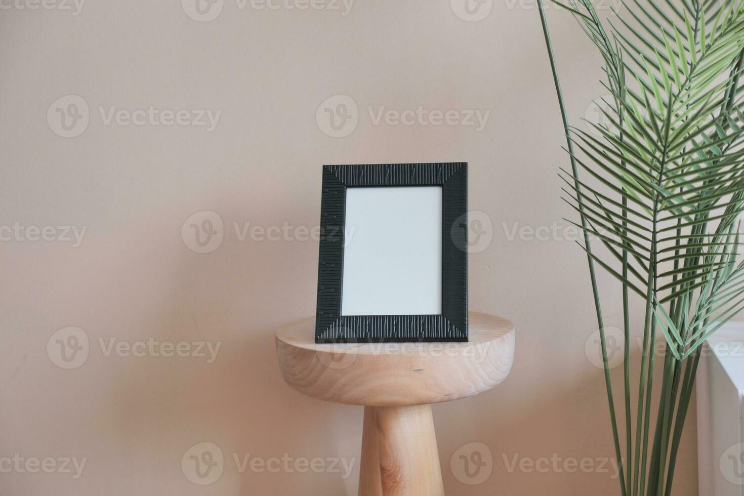 empty photo frame on table against white light orange color wall