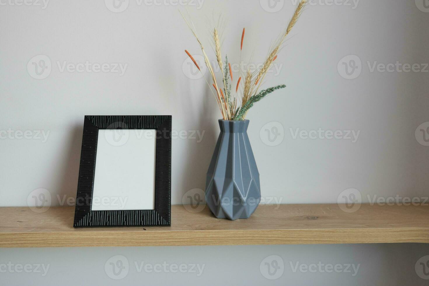 empty photo frame on table against white wall