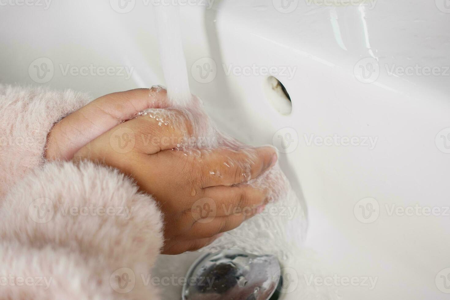 niño Lavado manos con calentar agua foto